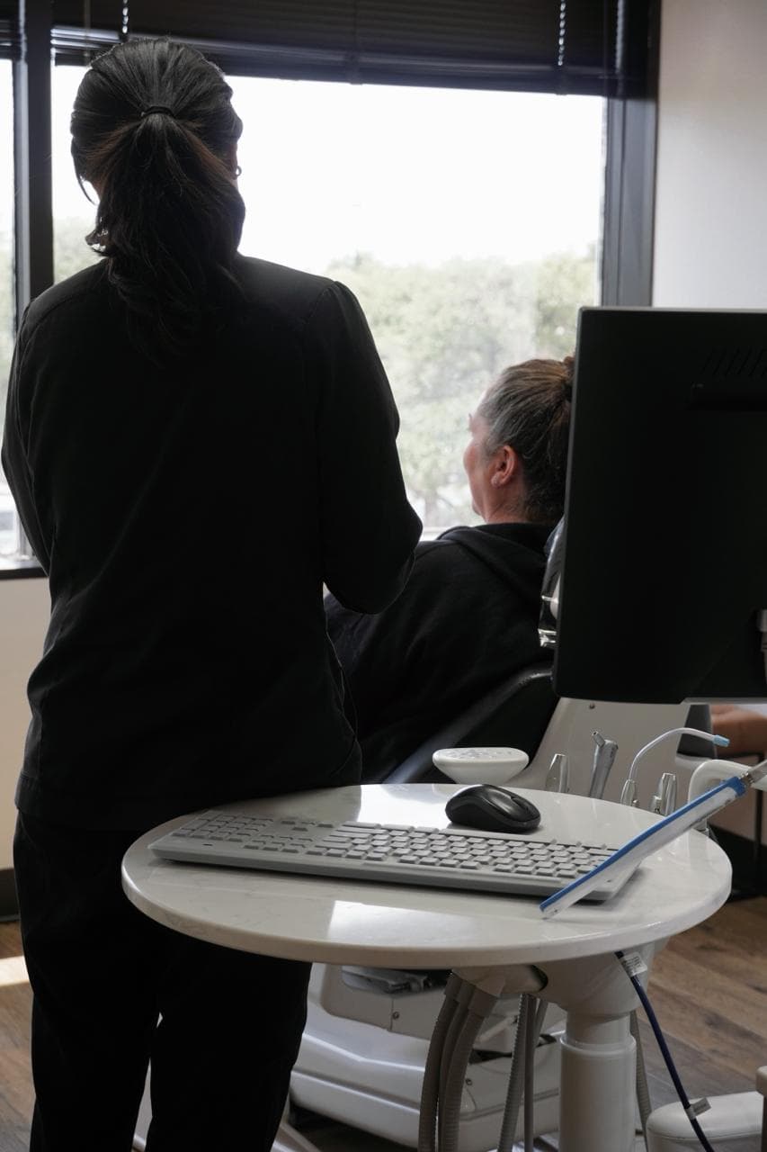 Smile Suite team member consulting with a patient beside a monitor