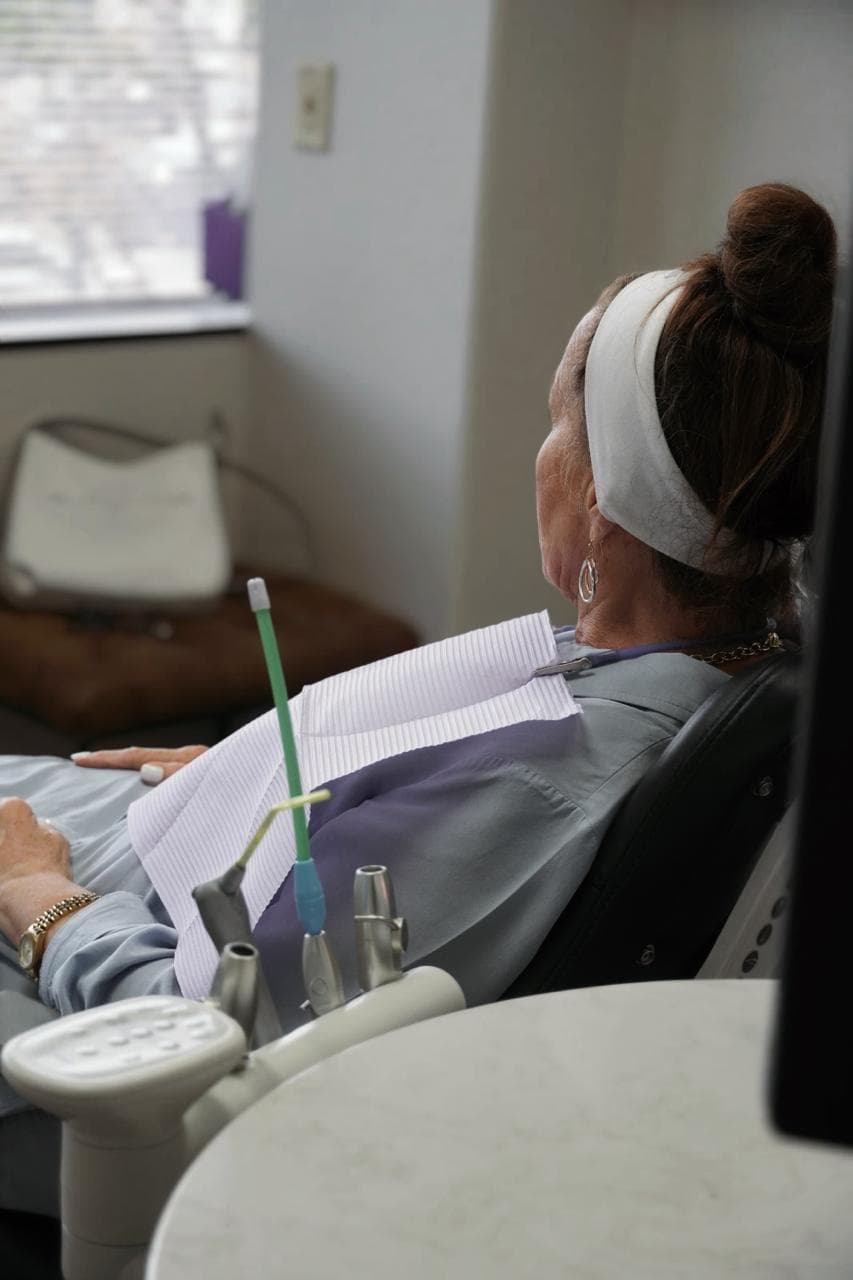 Patient seated comfortably in a treatment room during imaging at The Smile Suite